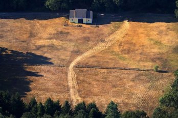 A Yellow barn in Topsfield, MA, matches the grass surrounding it.  Source: Boston Globe