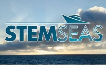 STEMSEAS logo in front of flat, dark blue ocean and white clouds in blue sky near sunset
