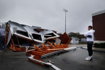 Cohasset High School football player Jackie Lyons examined a press box, destroyed by a storm, at Cohasset Alumni Field in O