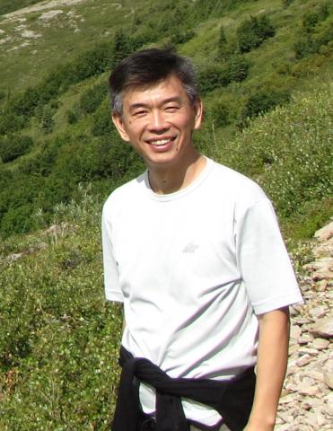 Photograph of Dr. Yang Shen, smiling on a mountainside.