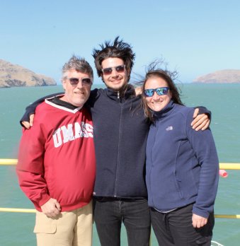 Dr. Leckie, Benjamin Keisling, and post-doc smiling at camera on deck of ship overlooking ocean
