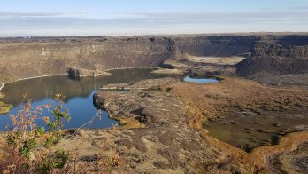 Dry Falls in Washington: a canyon carved out of orange stone in an arid landscape