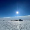 A quonset hut on a flat, featureless field of snow and ice in Anarctica