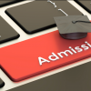 A zoomed in picture of a fictional keyboard, with the enter key replaced by a bright red key that says "Admissions".