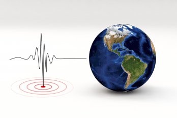 Image of earthquake seismograph next to blue-marble style globe.