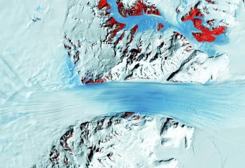  A satellite image shows the long flow lines as a glacier moves ice into Antarctica’s Ross Ice Shelf, on the right. The red patches mark bedrock. USGS 