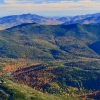 Fall scene of forest-clad Adirondack mountains upon mountains fading into distance.