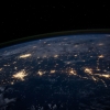 View of the earth at night from orbit, with cities on the continent currently called North America lit up.