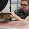 Hannah Elston preparing the model by sprinkling sand on the surface of the clay. Credit: UMass Amherst