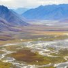 Photo of high artic mountain valley, with braided river winding its way though wide floodplain